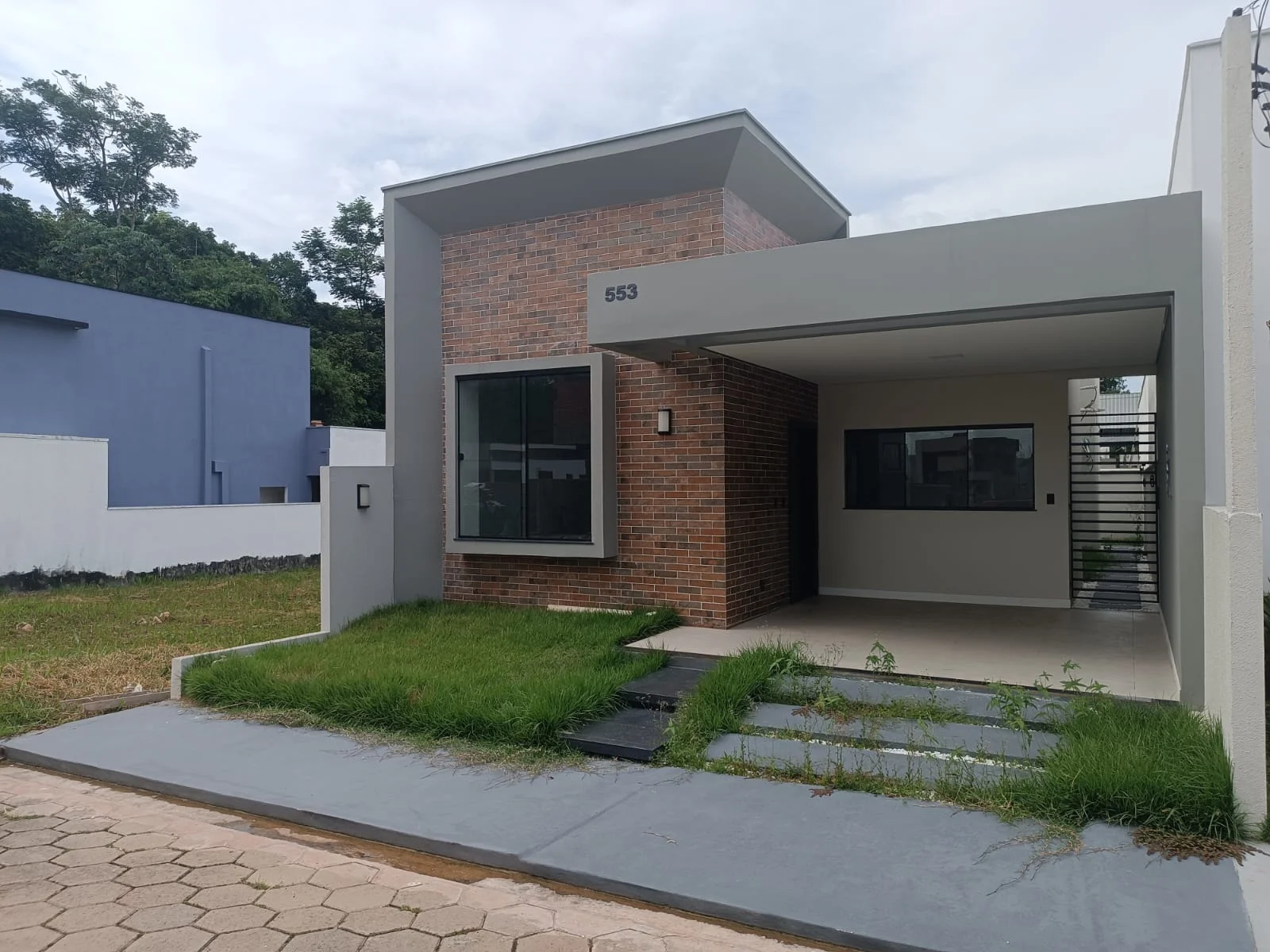 Volume da fachada: alvenaria revestida em tijolinho aparente e laje de cobertura da garagem