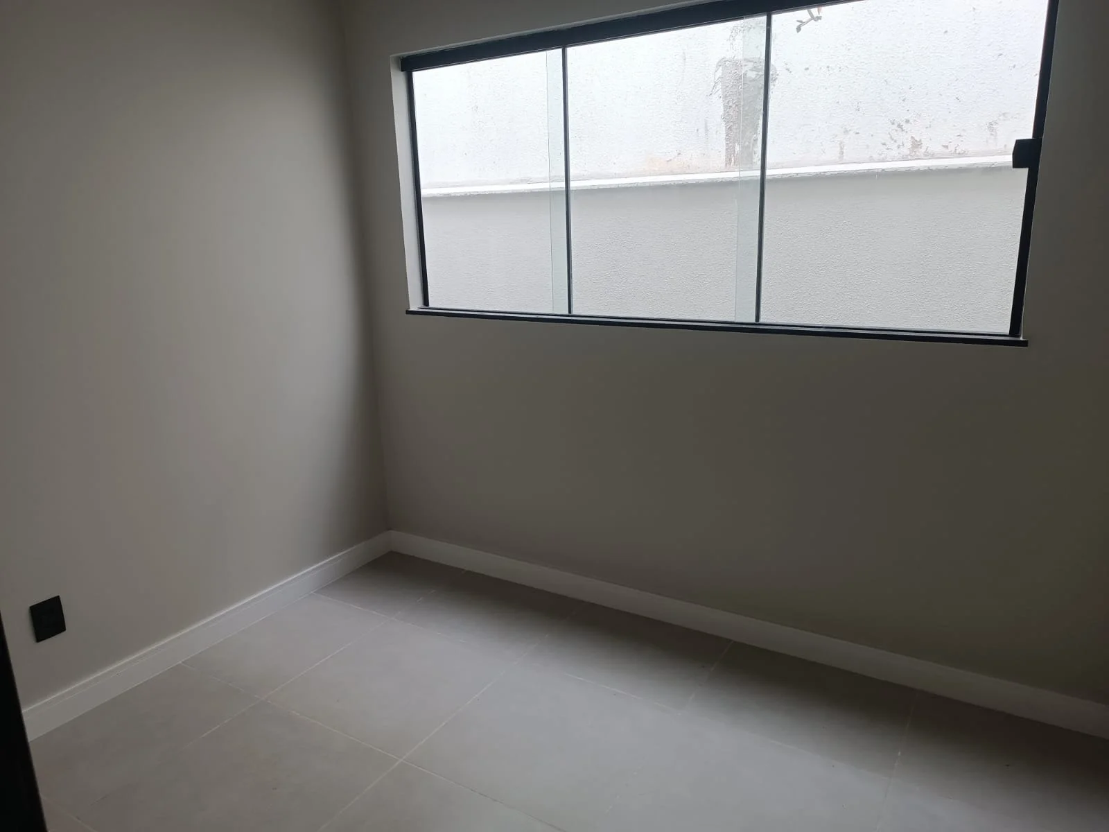 Dormitório com janela alta e piso em porcelanato
