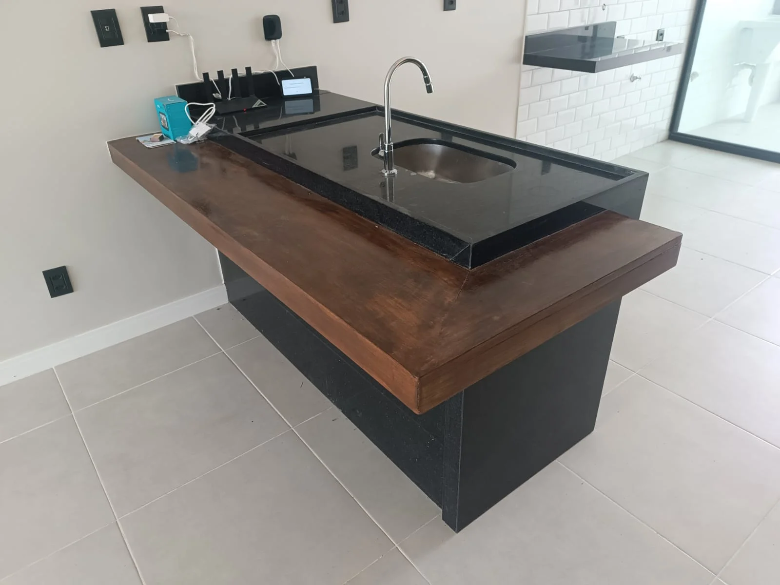 Bancada da cozinha em granito preto, com arremate em madeira e cuba embutida