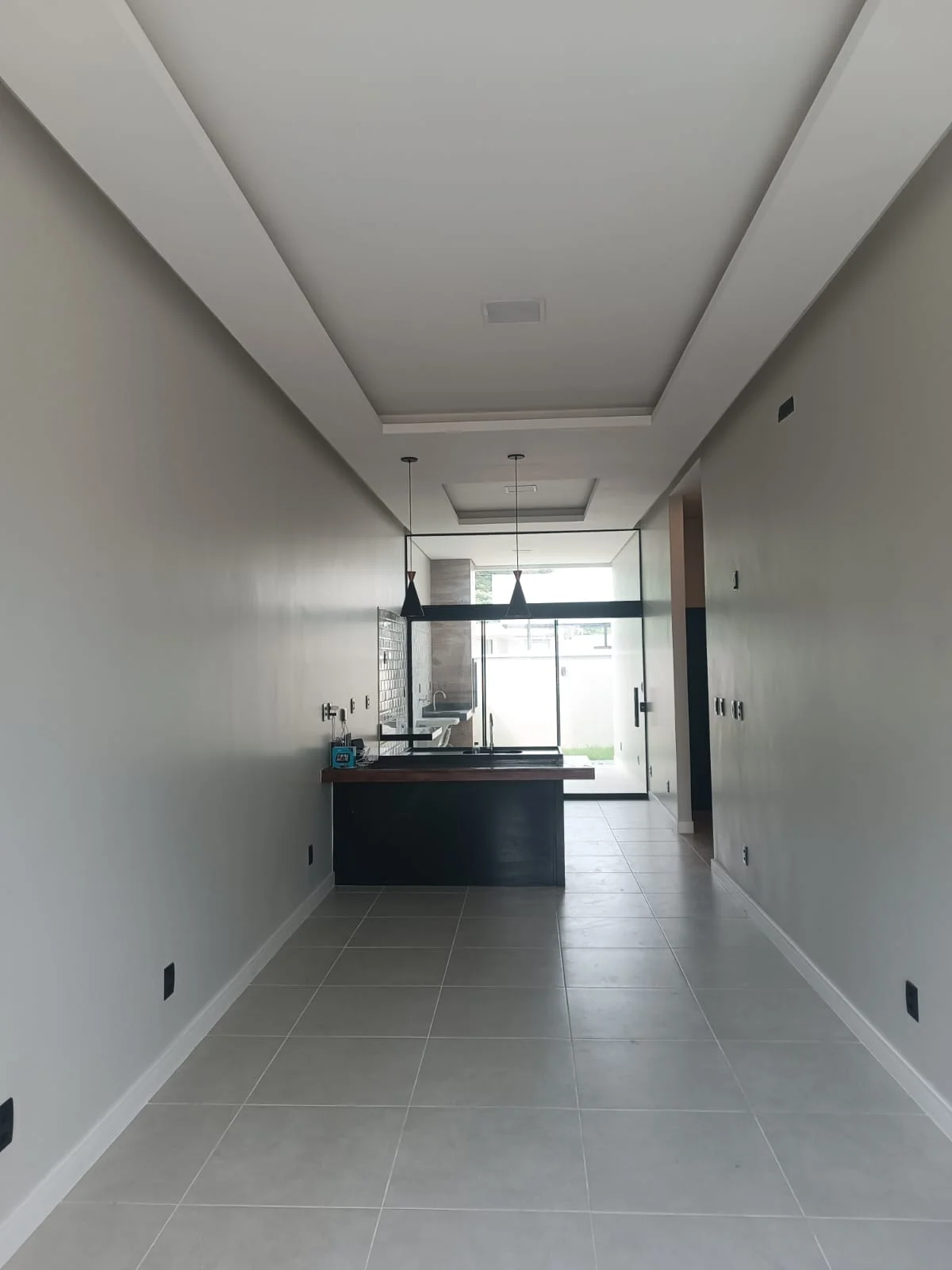 Sala de estar e jantar integradas, com vista para a cozinha e para o quintal