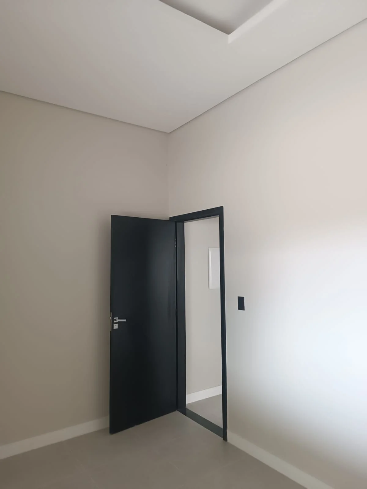 Esquadria interna: porta e batente pretos contra parede clara