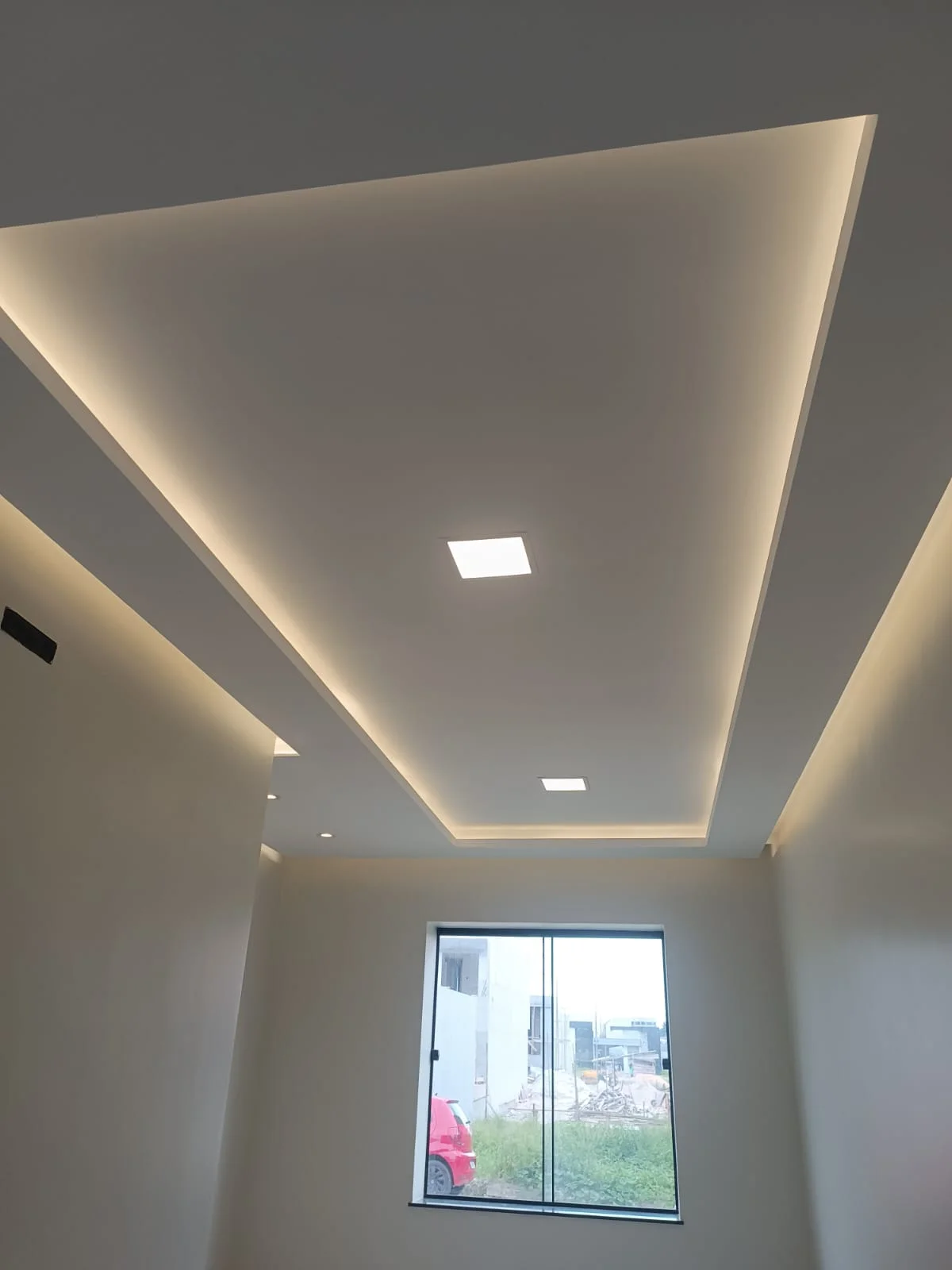 Forro rebaixado da sala, com rasgo de luz e luminárias embutidas