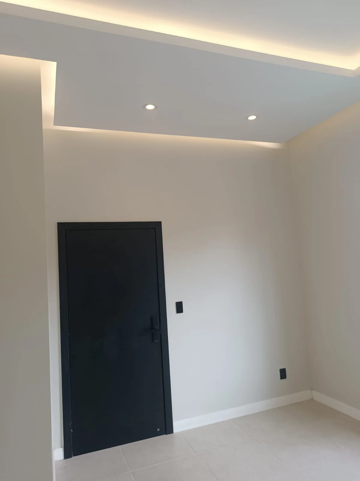 Hall de entrada com porta preta e iluminação embutida no forro