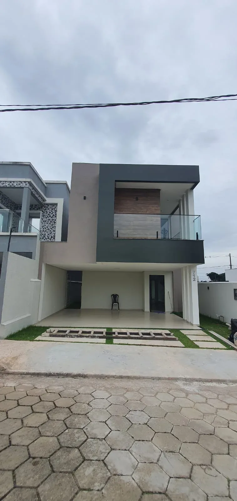 Fachada frontal com garagem coberta e jardim de acesso
