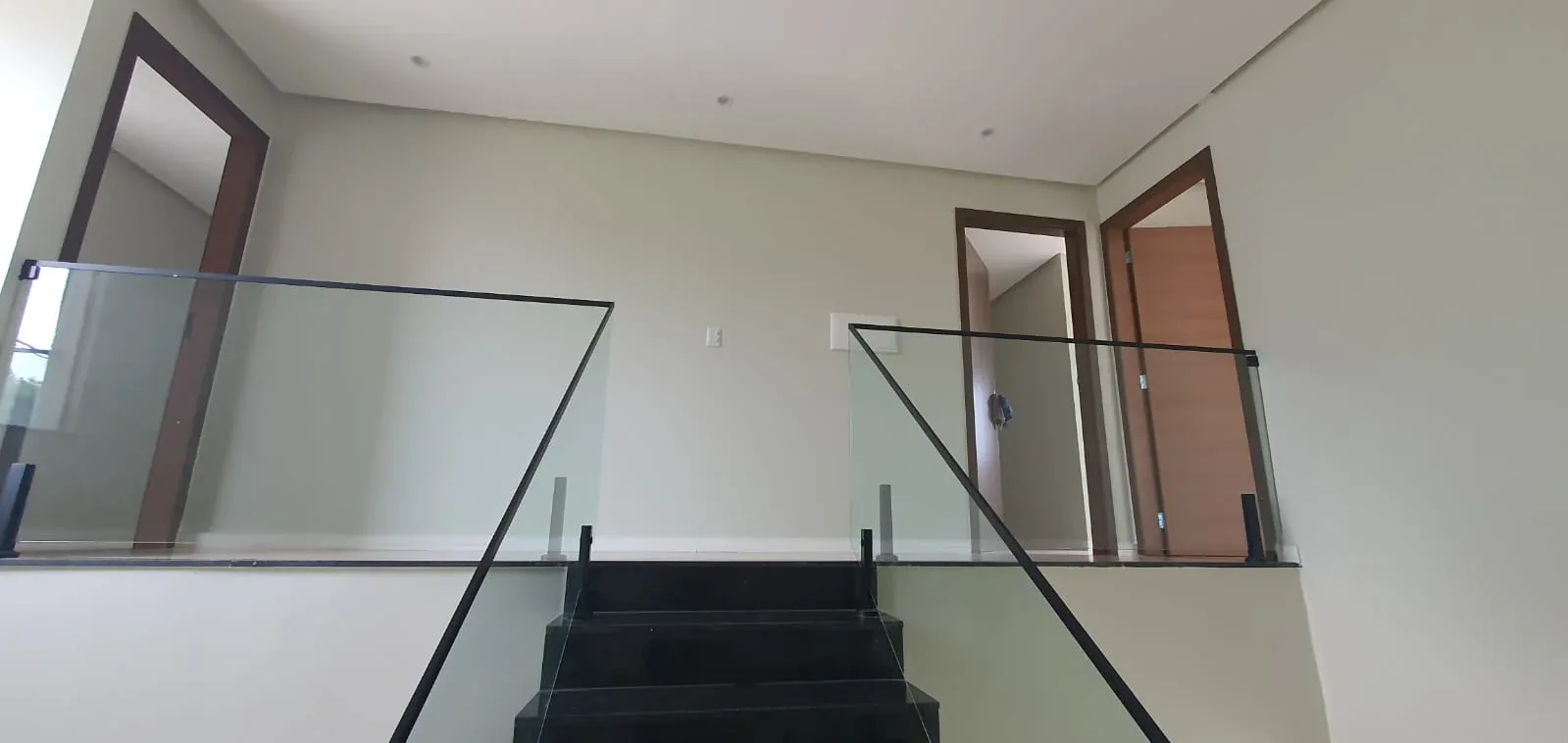 Hall do pavimento superior, com guarda-corpo de vidro