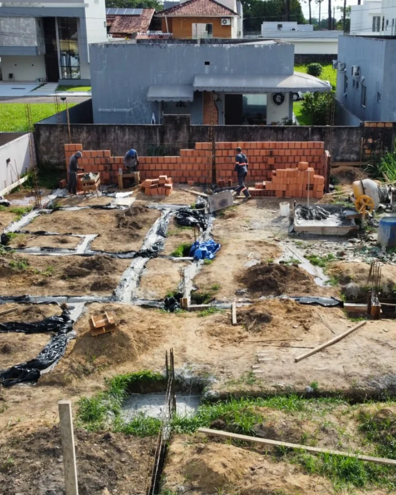 Equipe da MF levantando a alvenaria do muro divisório sobre os baldrames já executados, no Eco's Paradise