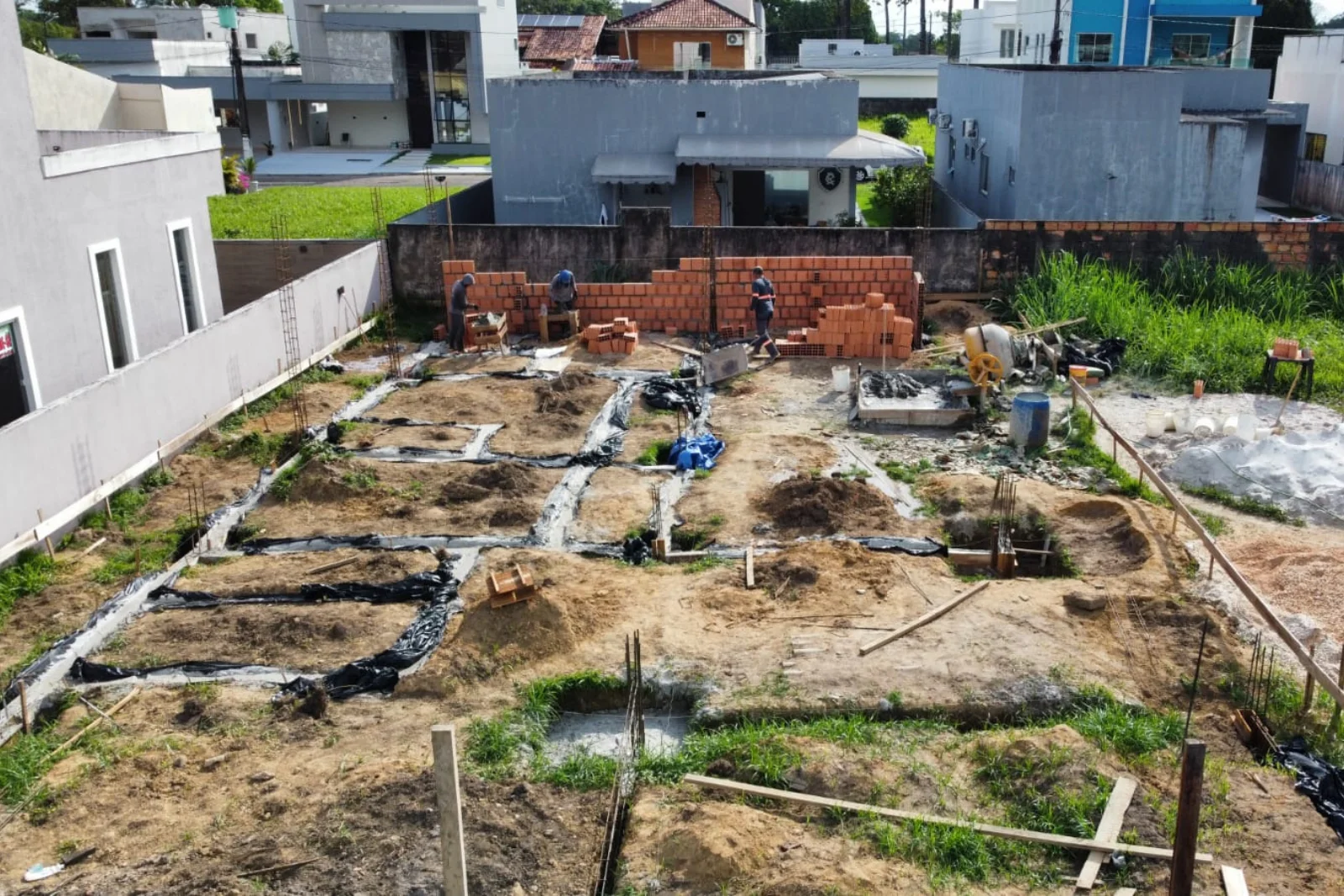 Terreno com fundação pronta e arranques de pilares aguardando a estrutura