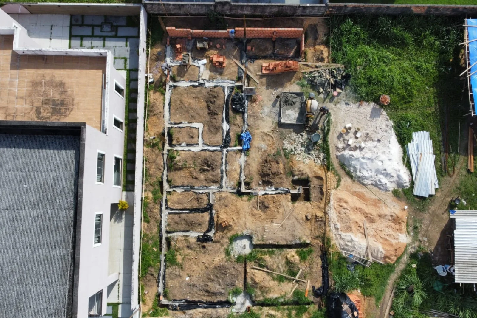 Vista aérea da fundação concluída e da central de materiais ao lado da obra