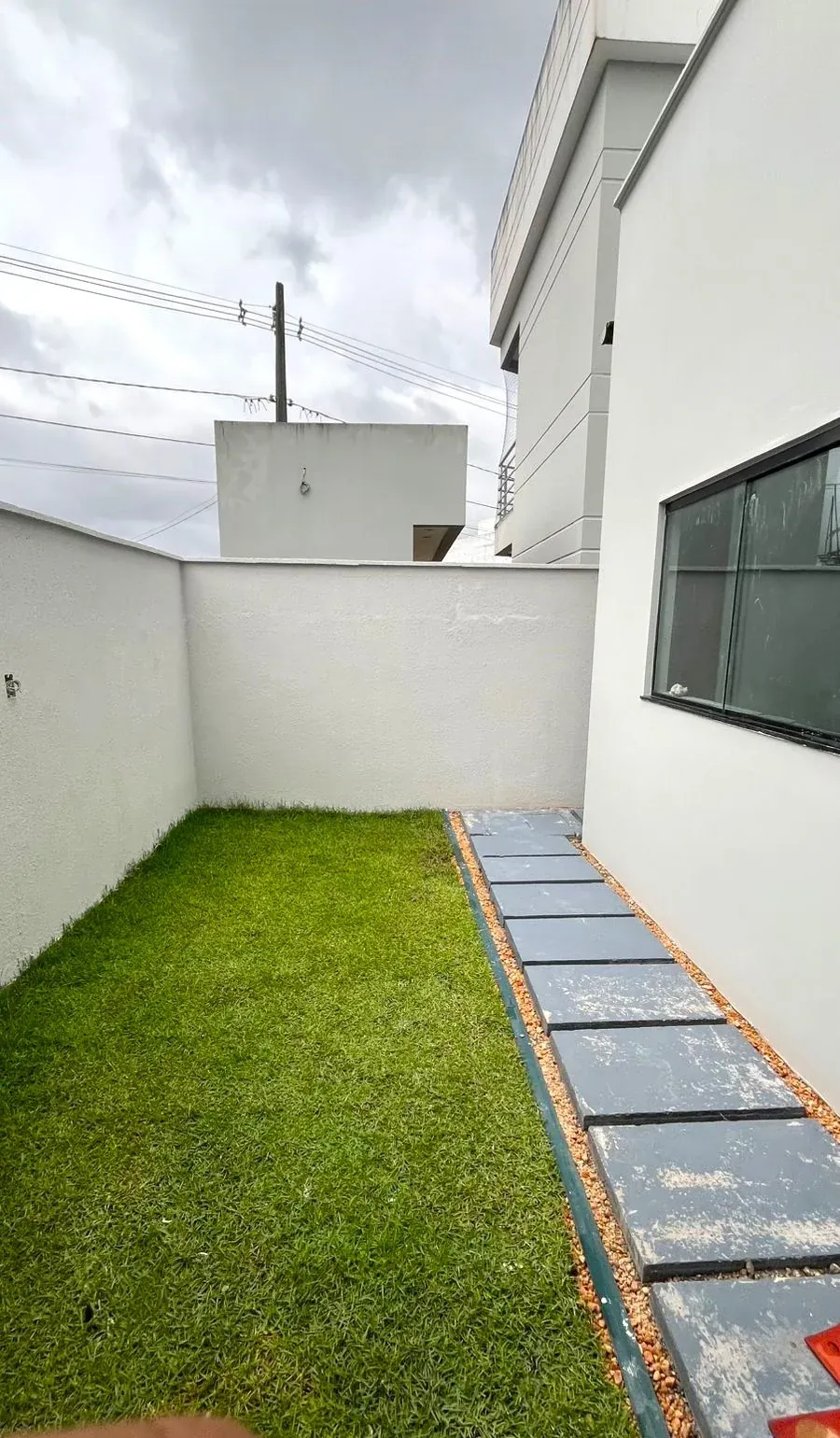 Quintal gramado com passeio de placas de concreto
