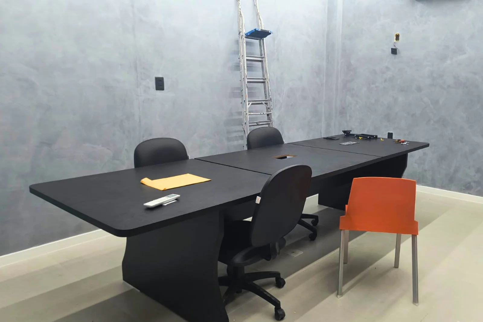 Sala de reunião com paredes em marmorato cinza